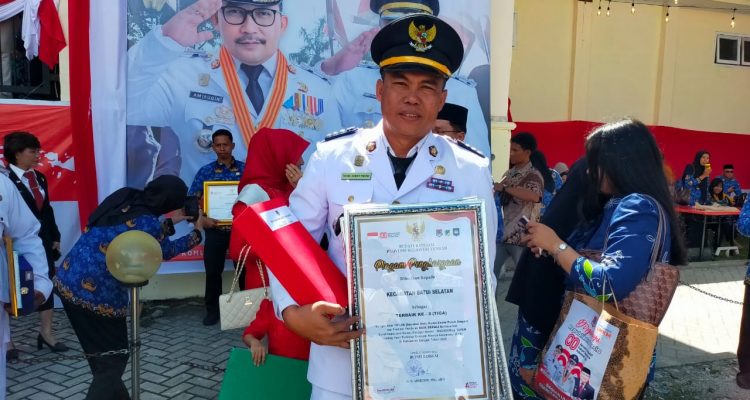 Camat Batui Selatan, Faidil Akbar Pasau saat menerima Penghargaan dari Bupati Banggai ( Foto IST)