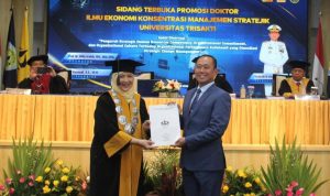 Penyerahan surat keterangan lulus sebagai Doktor Ilmu Ekonomi dari Dekan FEB Universitas Trisakti Prof. Dr. Yolanda Masnita (kiri) kepada Laksamana Muda TNI Hudiarto Krisno Utomo (kanan), Sabtu 11 Oktober 2025 (Foto: Dok. FEB Usakti)
