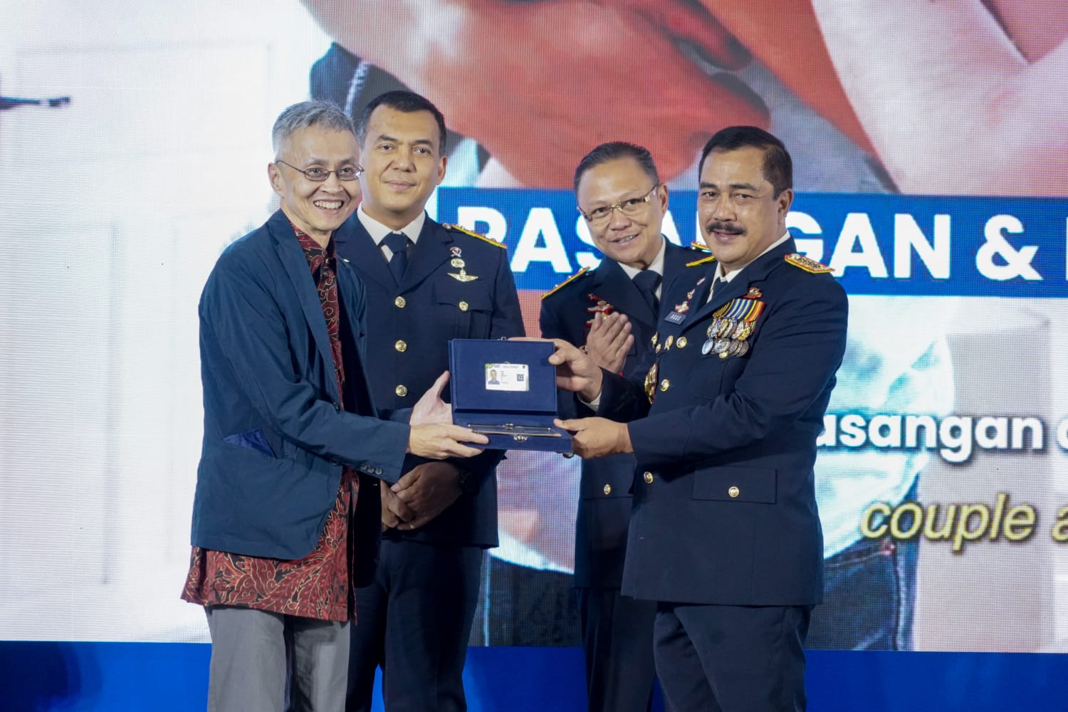 Menteri Imigrasi dan Pemasyarakatan RI, Agus Andrianto Saat memberikan Piagam Penghargaan kepada Salah Satu WNI pada Puncak Hari Bakti Imigrasi Ke 76