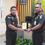 Kajari Banggai, Akbar SH MH saat memberikan Cinderamata kepada Kajati Sulteng saat melakukan Kunjungan Kerja di Kejaksaan Negeri Banggai