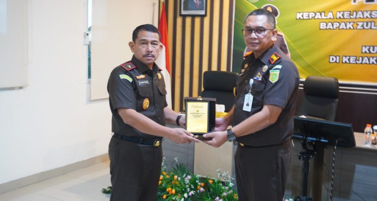 Kajari Banggai, Akbar SH MH saat memberikan Cinderamata kepada Kajati Sulteng saat melakukan Kunjungan Kerja di Kejaksaan Negeri Banggai
